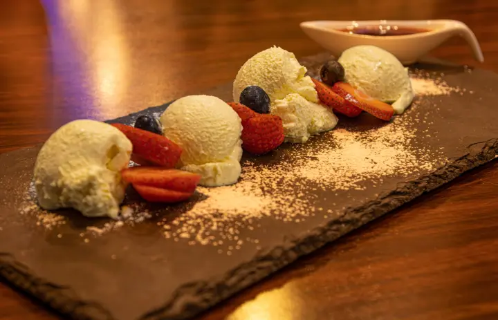 Dessert mit Eis und Erdbeeren auf einer Schieferplatte