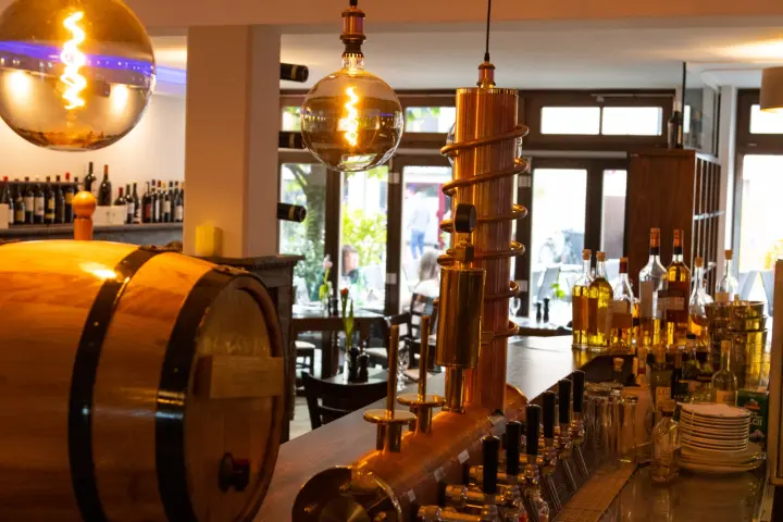 Theke mit Holzfass und kupferner Zapfanlage